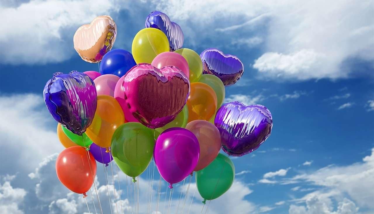 Colorful balloons and hearts with blue sky.