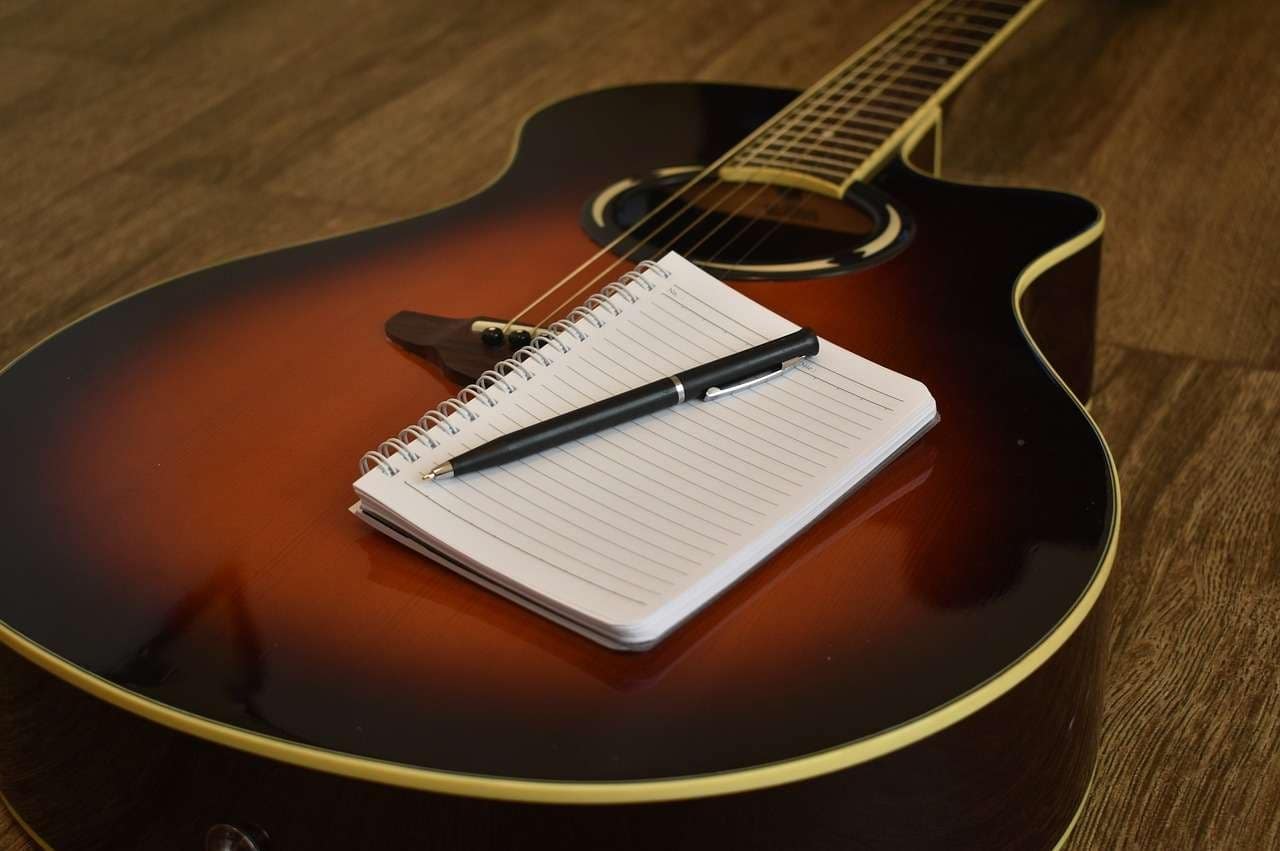 Acoustic guitar with writing pad and pencil