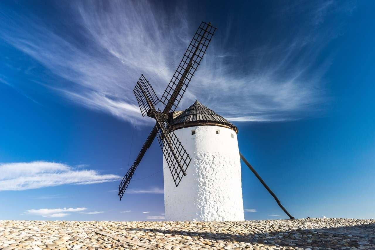 Spanish windmill under fair sky.